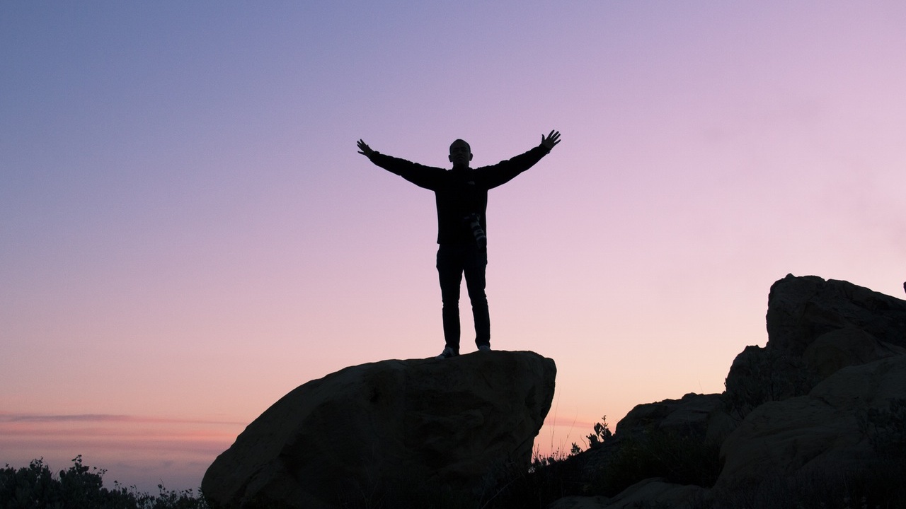 Man standing on rock sunrise