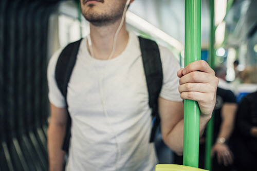 Student on a jostling bus, using headphones to listen to a video lesson with audio descriptions