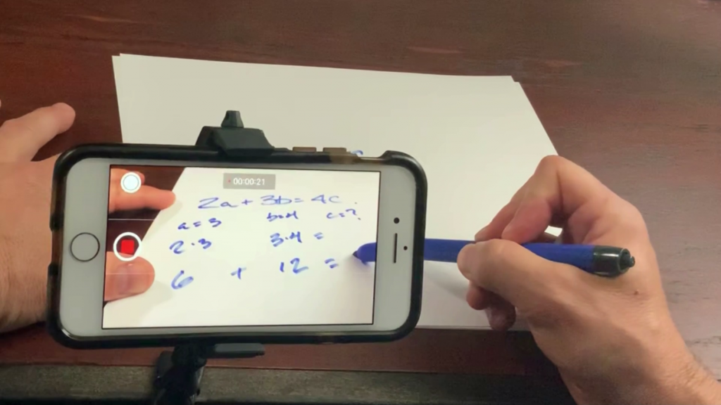 iPhone recording a person writing on paper