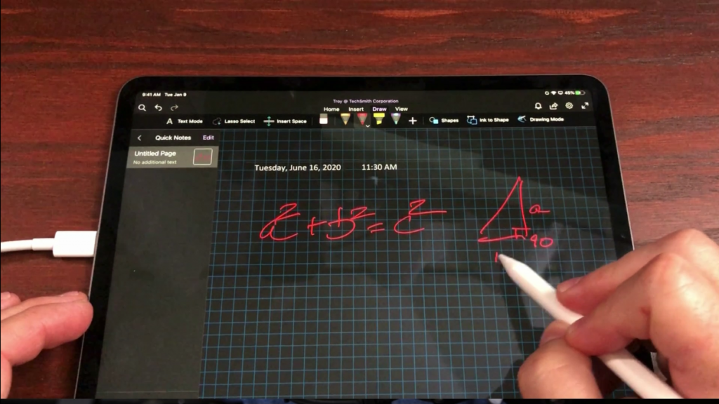 Person drawing a math equation on an iPad