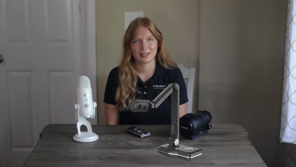 Person sitting at desk with mic and webcam