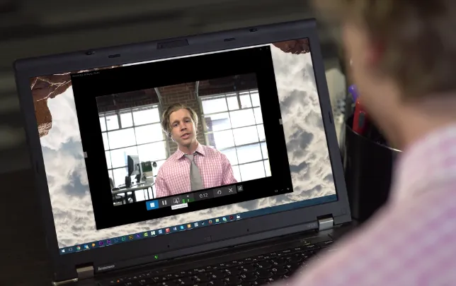 over-the-shoulder shot of professional man on webcam