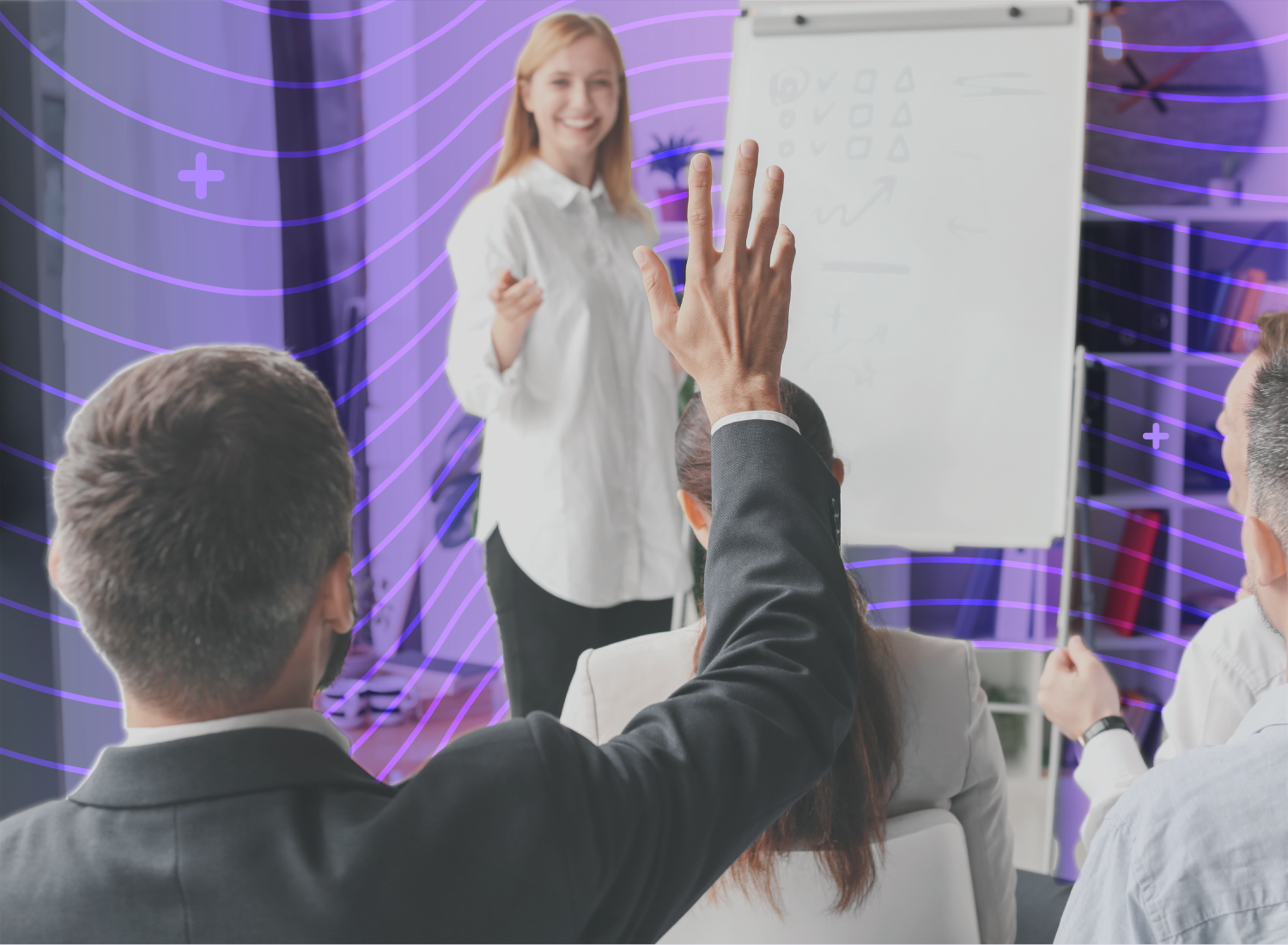 Employee raising hand during an interactive corporate training session led by a smiling instructor at a whiteboard.