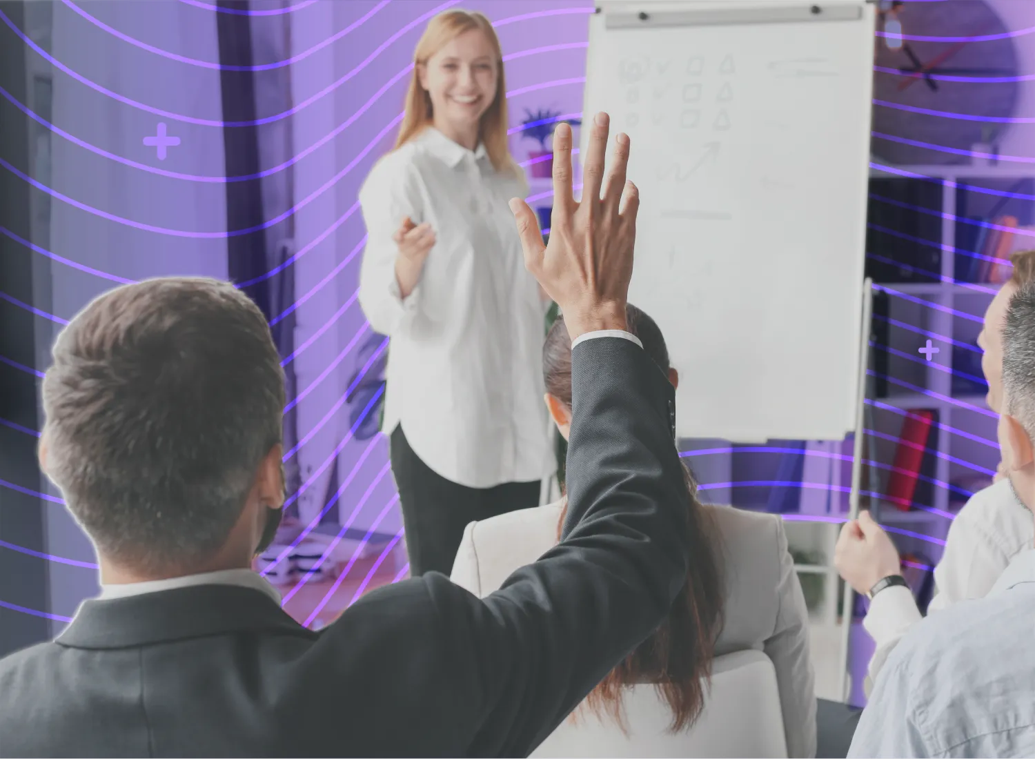 Employee raising hand during an interactive corporate training session led by a smiling instructor at a whiteboard.